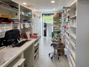 Agencement du back-office de la pharmacie de Dabo avec création et pose d'étagères en bois blanc pour les médicaments et intégration d'un bureau pour les pharmaciens